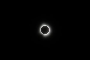 A total solar eclipse seen in a dark sky, with the sun’s corona around the moon.