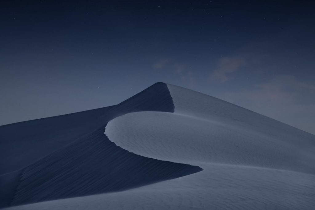 A desert landscape beneath a dark night sky.