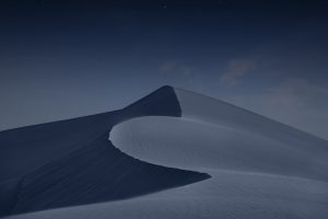 A desert landscape beneath a dark night sky.