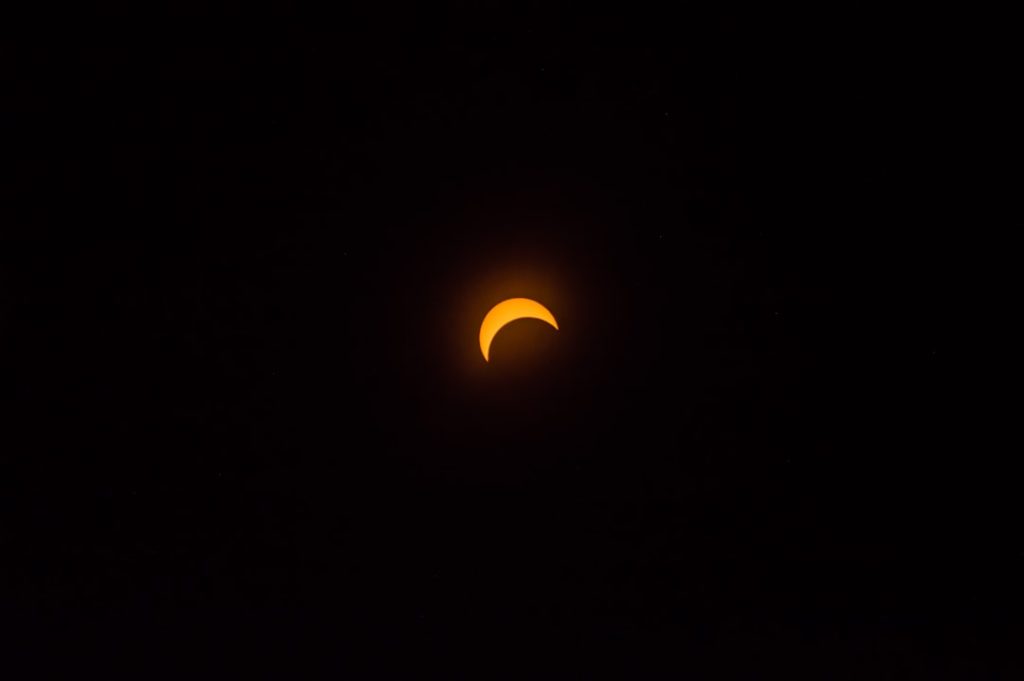 A solar eclipse in a darkened sky.