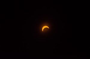 A solar eclipse in a darkened sky.