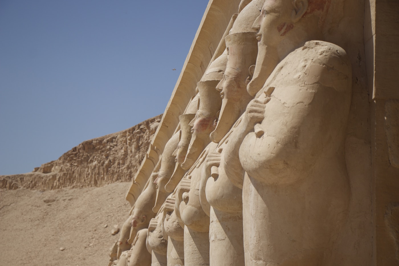 The Theban hills above the Luxor west bank at dawn, with the temple statues and cliffs